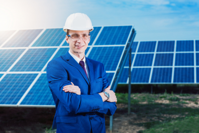 business man in a suit near the solar panels to power plants